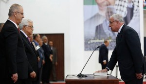 Palestinian Foreign Minister Riyad al-Maliki takes his oath of office in front of Palestinian President Mahmoud Abbas during a swearing-in ceremony of the unity government, in the West Bank city of Ramallah