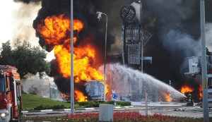 Israeli fire-fighters extinguish a fire that broke out after a rocket hit a petrol station in the southern Israeli city of Ashdod