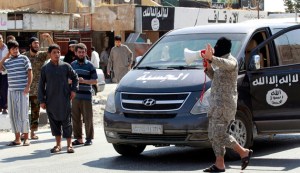 Islamic State militant uses a loud-hailer to announce to residents of Tabqa city that Tabqa air base has fallen to Islamic State militants, in nearby Raqqa city