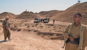 Kurdish peshmerga fighters stand guard around vehicles left behind by fleeing Islamic State militants during clashes in the al-Zerga area near Tikrit city