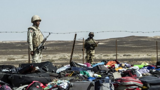 Egyptian army soldiers stand guard next to the luggage and belongings of passengers of the A321 Russian airliner piled up at the site of the crash in Wadi el-Zolmat, a mountainous area in Egypt's Sinai Peninsula on November 1, 2015. (AFP PHOTO / KHALED DESOUKI)