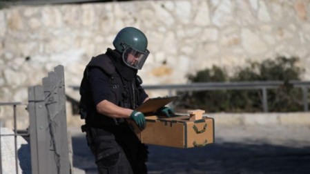 A police sapper removes a suspected explosive device at the scene of a shooting and stabbing attack near Damascus Gate, Jerusalem, February 3, 2016. (Yonatan Sindel/Flash90)