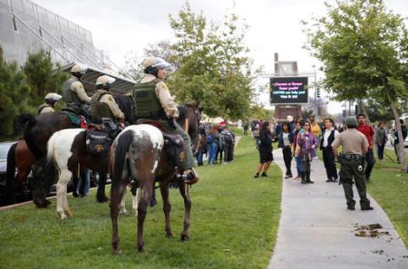 Los Angeles County Sheriff Mounted Enforcement Detail keep protestors at a distance as Democratic presidential candidate Hillary Clinton campaigns at East Los Angeles College in Los Angeles, Thursday, May 5, 2016. (AP Photo/Damian Dovarganes)