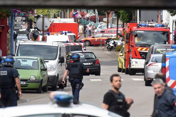 The area has been placed on lockdown as sniffer dogs search the area Police and rescue workers stand at the scene after two assailants had taken five people hostage in the church at Saint-Etienne-du -Rouvray near Rouen