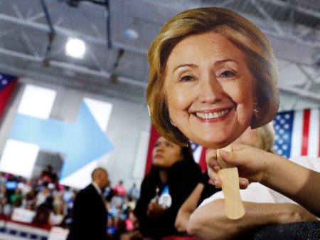 Hunter Lassus, 7, of Seven Hills, Ohio, holds an image of Democratic presidential candidate Hillary Clinton during a campaign event at John Marshall High School in Cleveland, Wednesday, Aug. 17, 2016. (AP Photo/Carolyn Kaster)