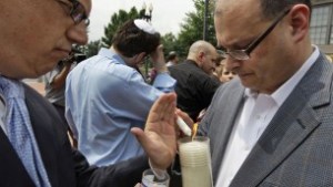 David Schwake, from the German Embassy, left, lights a candle with Ron Halber, from the JCRC in front of the US Holocaust Museum after a shooting left a security officer dead and the gunman wounded. (Alex Brandon/AP) 