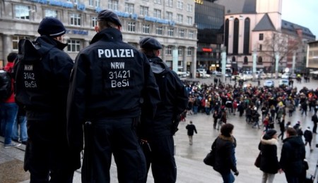 Policemen look on as refugees from Syria demonstrate against violence near the Cologne main train station in Cologne, western Germany on January 16, 2016, where hundreds of women were groped and robbed in a throng of mostly Arab and North African men during New Year's festivities. German authorities said that nearly all the suspects in a rash of New Year's Eve violence against women in Cologne were "of foreign origin", as foreigners came under attack amid surging tensions. / AFP / PATRIK STOLLARZ (Photo credit should read PATRIK STOLLARZ/AFP/Getty Images)