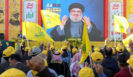 People watch Lebanon's Hezbollah leader Sayyed Hassan Nasrallah as he appears on a screen during a live broadcast to speak to his supporters at an event marking Resistance and Liberation Day, in Bekaa valley May 25, 2016. The event is to commemorate the 16th anniversary of Israel's withdrawal from southern Lebanon. REUTERS/Hassan Abdallah - RTSFWSN