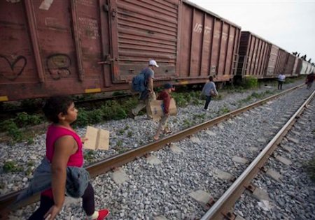 FILE - In this July 12, 2014 file photo, migrants walk along the rail tracks after getting off a train during their journey toward the U.S.-Mexico border in Ixtepec, Mexico. Many of the immigrants recently flooding the nationís southern border say theyíre fleeing violent gangs in Central America. These gangs were a byproduct of U.S. immigration and Cold War policies, specifically growing from the increase in deportations in the 1990s. With weak dysfunctional governments at home, U.S. street gang culture easily took hold and flourished in these countries. (AP Photo/Eduardo Verdugo)