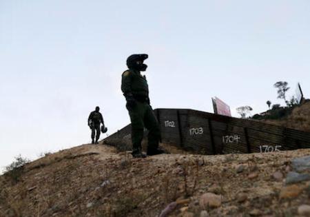 FILE - In this Wednesday, June 22, 2016, file photo, Border Patrol agents look over the primary fence separating Tijuana, Mexico, right, and San Diego in San Diego. An estimated 40 percent of the 11.4 million people in the U.S. illegally overstayed visas, a crucial but often overlooked fact in the immigration debate. More people overstayed visas than were caught crossing the border illegally. (AP Photo/Gregory Bull, File)