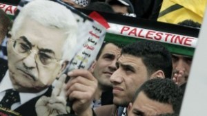 A man holds up an image of Palestinian Authority President Mahmoud Abbas as Palestinians rally in the center of the West Bank city of Nablus in support of Abbas during his visit to Washington, March 17, 2014. (Jaafar/ Ashtiyeh/AFP)