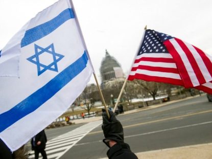 A pro-Israel demonstrators waves flags, toward the Capitol in Washington, Tuesday, March 3, 2015, as Israeli Prime Minister Benjamin Netanyahu addressed a joint meeting of Congress. In a speech that stirred political intrigue in two countries, Netanyahu told Congress that negotiations underway between Iran and the U.S. would "all but guarantee" that Tehran will get nuclear weapons, a step that the world must avoid at all costs. (AP Photo/Cliff Owen)