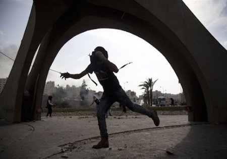 A Palestinian hurls a stone during clashes with Israeli troops, near Ramallah, West Bank, Tuesday, Oct. 20, 2015. U.N. Secretary-General Ban Ki-moon called for calm during a surprise visit to Jerusalem on Tuesday ahead of meetings with Israeli and Palestinian leaders, in a high-profile gambit to bring an end to a monthlong wave of violence. (AP Photo/Majdi Mohammed)