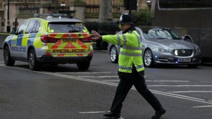 A police officer stops traffic as the Jaguar car of British Prime Minister Theresa May (R) is driven away from the Houses of Parliament in central London on March 22, 2017 during an emergency incident. (AFP PHOTO / Daniel LEAL-OLIVAS)