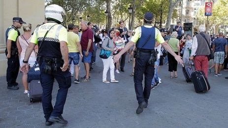 Police officers tell members of the public to leave the scene in a street in Barcelona, Spain, Thursday, Aug. 17, 2017. Police in the northern Spanish city of Barcelona say a white van has jumped the sidewalk in the city's historic Las Ramblas district, injuring several people. (AP Photo/Manu Fernandez)