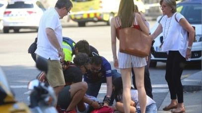 An injured person is treated in Barcelona, Spain, Thursday, Aug. 17, 2017 after a white van jumped the sidewalk in the historic Las Ramblas district, crashing into a summer crowd of residents and tourists and injuring several people, police said. (AP Photo/Oriol Duran)