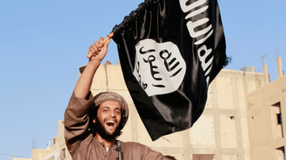 Illustrative: An Islamic State terrorist waves the jihadist organization's flag (CC BY-SA Alatele fr, Flickr)