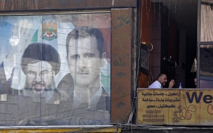 A poster bearing an image of Syrian President Bashar al-Assad (R) and Hassan Nasrallah, head of Lebanese Shiite movement Hezbollah, is seen in Damascus on September 7, 2017. (AFP/LOUAI BESHARA)