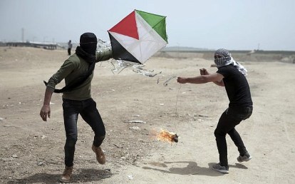 Illustrative: Palestinian protesters fly a kite with a burning rag dangling from its tail, during a protest at the Gaza Strip's border with Israel, April 20, 2018. Activists use kites with firebombs and burning rags dangling from their tails to set ablaze drying wheat fields on the Israeli side. (AP Photo/Khalil Hamra)