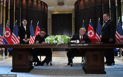 US President Donald Trump (2nd R) and North Korea's leader Kim Jong Un (2nd L) sign documents as US Secretary of State Mike Pompeo (R) and the North Korean leader's sister Kim Yo Jong (L) look on at a signing ceremony during their historic US-North Korea summit, at the Capella Hotel on Sentosa island in Singapore on June 12, 2018. (SAUL LOEB / AFP) US President Donald Trump (2nd R) and North Korea's leader Kim Jong Un (2nd L) sign documents as US Secretary of State Mike Pompeo (R) and the North Korean leader's sister Kim Yo Jong (L) look on at a signing ceremony during their historic US-North Korea summit, at the Capella Hotel on Sentosa island in Singapore on June 12, 2018. (SAUL LOEB / AFP)