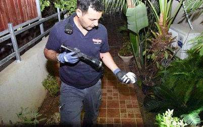 An Israel Police sapper inspects a piece of a rocket fired from the Gaza Strip that struck a house in the southern Israeli town of Sderot on August 8, 2018. (Israel Police)