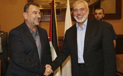 In this photo released by the Hamas Media Office, Ismail Haniyeh, right, the head of the Hamas political bureau, shakes hands with his deputy Saleh el-Arouri upon his arrival in Gaza from Cairo, Egypt, in Gaza City, Thursday, Aug. 2, 2018. (Mohammad Austaz/Hamas Media Office via AP)