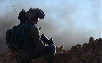 Illustrative: Israeli soldiers in defensive positions on an embankment near the Gaza border during a violent Palestinian protest, July 27, 2018 (Courtesy IDF)