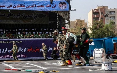 This picture taken on September 22, 2018 in the southwestern Iranian city of Ahvaz shows Iranian soldiers carrying away an injured colleague at the scene of an attack on a military parade that was marking the anniversary of the outbreak of its devastating 1980-1988 war with Saddam Hussein's Iraq. (AFP/ ISNA / MORTEZA JABERIAN)