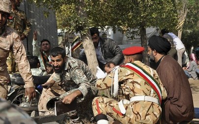In this photo provided by the Iranian Students' News Agency, ISNA, Iranian armed forces members and civilians take shelter in a shooting during a military parade marking the 38th anniversary of Iraq's 1980 invasion of Iran, in the southwestern city of Ahvaz, Iran, Sept. 22, 2018 (AP Photo/ISNA, Behrad Ghasemi)