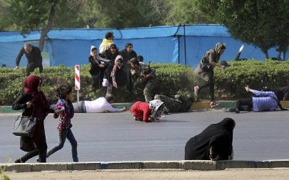 In this photo provided by Mehr News Agency, civilians try to take shelter in a shooting scene, during a military parade marking the 38th anniversary of Iraq's 1980 invasion of Iran, in the southwestern city of Ahvaz, Iran, Sept. 22, 2018 (AP Photo/Mehr News Agency, Mehdi Pedramkhoo)