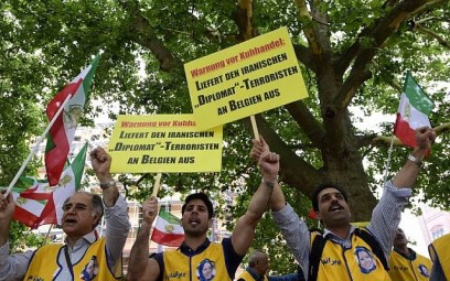 In this file photo taken on July 11, 2018, activists of the National Council of Resistance of Iran (NCRI) hold placards in front of the Federal Foreign Office in Berlin reading 'Deliver the Iranian diplomat-terrorist to Belgium' during a demonstration calling for the extradition of an Iranian diplomat to Belgium over suspicions that he was involved in plotting to bomb an opposition Iranian group's conference in Paris. (AFP Photo/Tobias Schwarz)