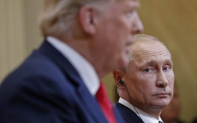 Russian President Vladimir Putin looks over toward US President Donald Trump, as Trump speaks during their joint news conference at the Presidential Palace in Helsinki, Finland, July 16, 2018. (AP Photo/Pablo Martinez Monsivais)