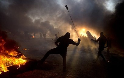 Black smoke from burning tires covers the sky as Palestinian protesters hurl stones toward Israeli troops during a protest at the Gaza Strip's border with Israel, Oct. 12, 2018. (AP Photo/Khalil Hamra) Black smoke from burning tires covers the sky as Palestinian protesters hurl stones toward Israeli troops during a protest at the Gaza Strip's border with Israel, Oct. 12, 2018. (AP Photo/Khalil Hamra)