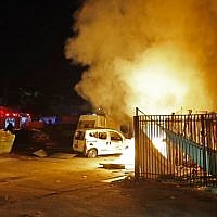 Israeli security forces and firefighters gather near a building set ablaze after it was hit by a rocket fired from the Palestinian enclave, in the southern town of Sderot on November 12, 2018. (Photo by Jack GUEZ / AFP)