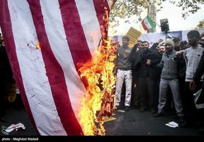 Iranian people burn the U.S. flag as they mark the anniversary of the seizure of the U.S. Embassy, in Tehran
