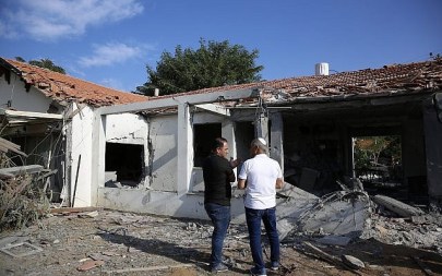 Officials assess the damage to a house after it was hit by a rocket fired by Palestinian militants from the Gaza Strip, in the southern Israeli city of Ashkelon, Israel, Tuesday, Nov. 13, 2018. (AP Photo/Ariel Schalit)
