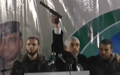 In this November 16, 2018 image, Hamas's Gaza chief Yahya Sinwar holds up a handgun with a silencer he says was captured from Israeli special forces during a firefight in the Gaza Strip on November 11 (YouTube screenshot)