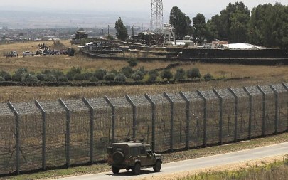 A picture taken on July 4, 2018 from the Golan Heights shows displaced Syrians from the province of Daraa staging a protest (top L) calling for international protection, in the Syrian village of al-Rafid, near the border fence with Israel. (AFP/Jalaa Marey)