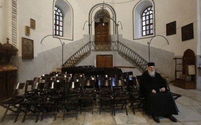 A priest prays inside the Nativity church in the West Bank town of Bethlehem.December 24,2018. (HAZEM BADER/AFP)