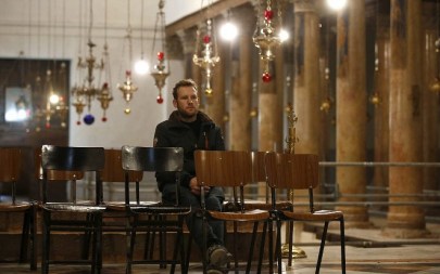 A Christian worshipper sits inside the Church of the Nativity in the biblical West Bank city of Bethlehem, on December 24,2018. (HAZEM BADER/AFP)