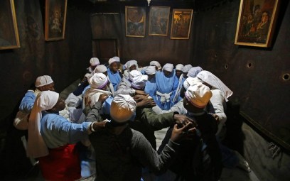 Nigerian pilgrims pray inside the Grotto, believed to be the exact spot where Jesus Christ was born, at the Church of the Nativity in the biblical West Bank city of Bethlehem, on the eve of the Christmas celebration, December 24, 2018. (Musa Al SHAER/AFP)