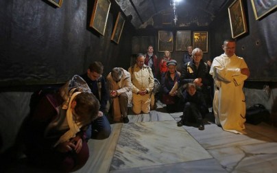 Christian pilgrims pray inside the Grotto, believed to be the exact spot where Jesus Christ was born, at the Church of the Nativity in the biblical West Bank city of Bethlehem, on Christmas eve, December 24, 2018. (Musa Al SHAER/AFP)