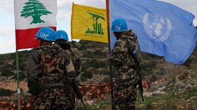 UN peacekeepers hold their flag while standing next to Hezbollah and Lebanese flags along the border (Photo: AP)