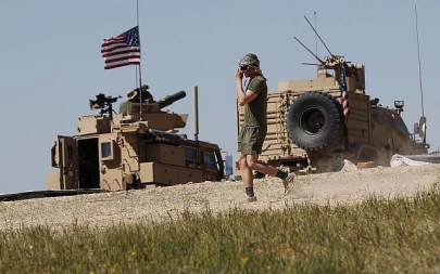 A US soldier walks on a newly installed position, near the tense front line between the US-backed Syrian Manbij Military Council and the Turkish-backed fighters, in Manbij, north Syria, April 4, 2018. (AP/Hussein Malla)