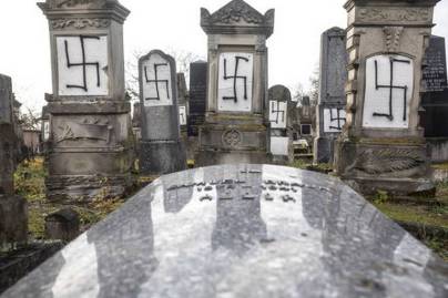 Jewish tombstones are desecrated with swastikas in the Herrlisheim Jewish cemetery, north of Strasbourg, eastern France, Thursday, Dec. 13, 2018. Dozens of tombs were defaced were discovered Tuesday.