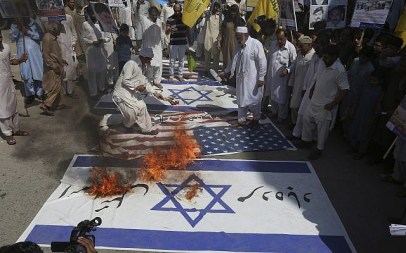 Shiite Muslims burn representation of Israeli and US flags during a rally to mark Al-Quds (Jerusalem) Day in Peshawar, Pakistan, Friday, June 23, 2017. (AP Photo/Muhammad Sajjad)