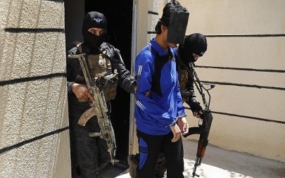 In this July 21, 2017, file photo, Kurdish soldiers from the Anti-Terrorism Units, carry a blindfolded an Indonesian man suspected of Islamic State membership, at a security center, in Kobani, Syria (AP Photo/Hussein Malla, File)