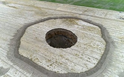 This frame grab from an August 8, 2018, video provided by Iranian Students' News Agency, ISNA, shows an aerial view of a massive hole caused by drought and excessive water pumping in Kabudarahang, in Hamadan province, in western Iran. (ISNA via AP)
