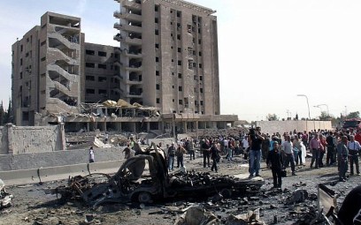Illustrative photo of Syrians gathering in front of a damaged military intelligence building where two bombs exploded, in the Qazaz neighborhood in Damascus, Syria, May 10, 2012. (Bassem Tellawi/AP)