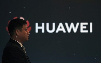 In this Jan. 9, 2019, photo, a security guard stands near the Huawei company logo during a new product launching event in Beijing (AP Photo/Andy Wong)